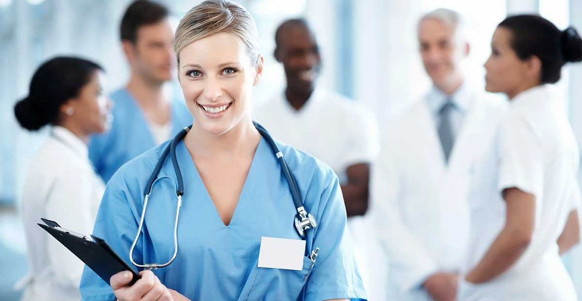 Female nurse holding clipboard with medical team in background